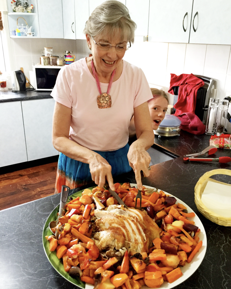My mum carving up the roast turkey. A big platter with plenty of roast veggies looks amazing!